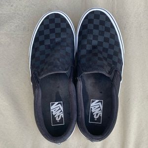 Black on black checkered vans slip ons.